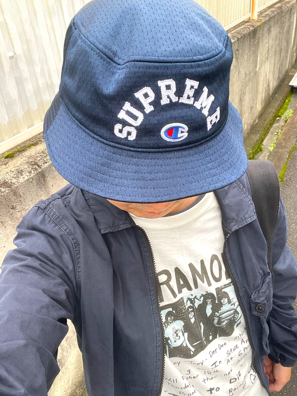 ブラック系のスニーカー、ブルー系のデニムパンツ、ブルー系のミリタリージャケットを着用したメンズの夏コーディネートの2枚目の写真