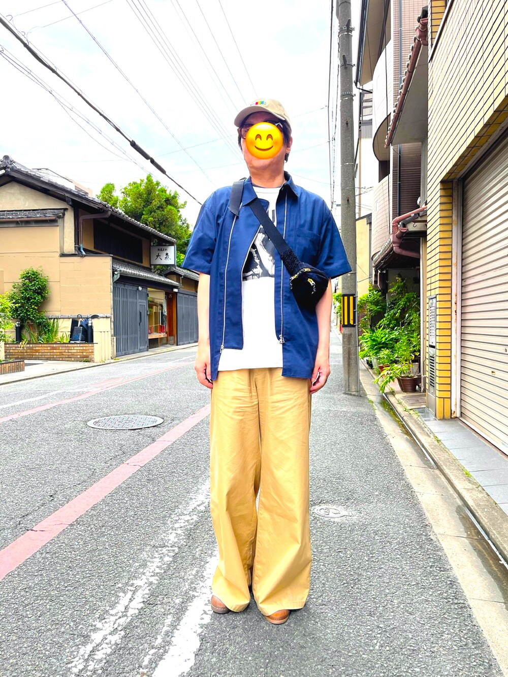 ブルー系のシャツ/ブラウス、ベージュ系のチノパンツ、ブルー系のボディバッグ/ウエストポーチを着用したメンズの夏コーディネートの2枚目の写真