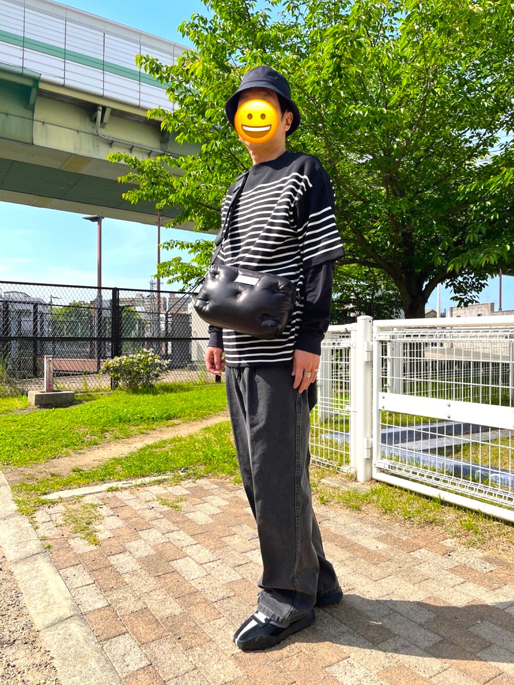 ブラック系のスニーカー、グレー系のデニムパンツ、ブラック系のショルダーバッグを着用したメンズの春コーディネートの2枚目の写真