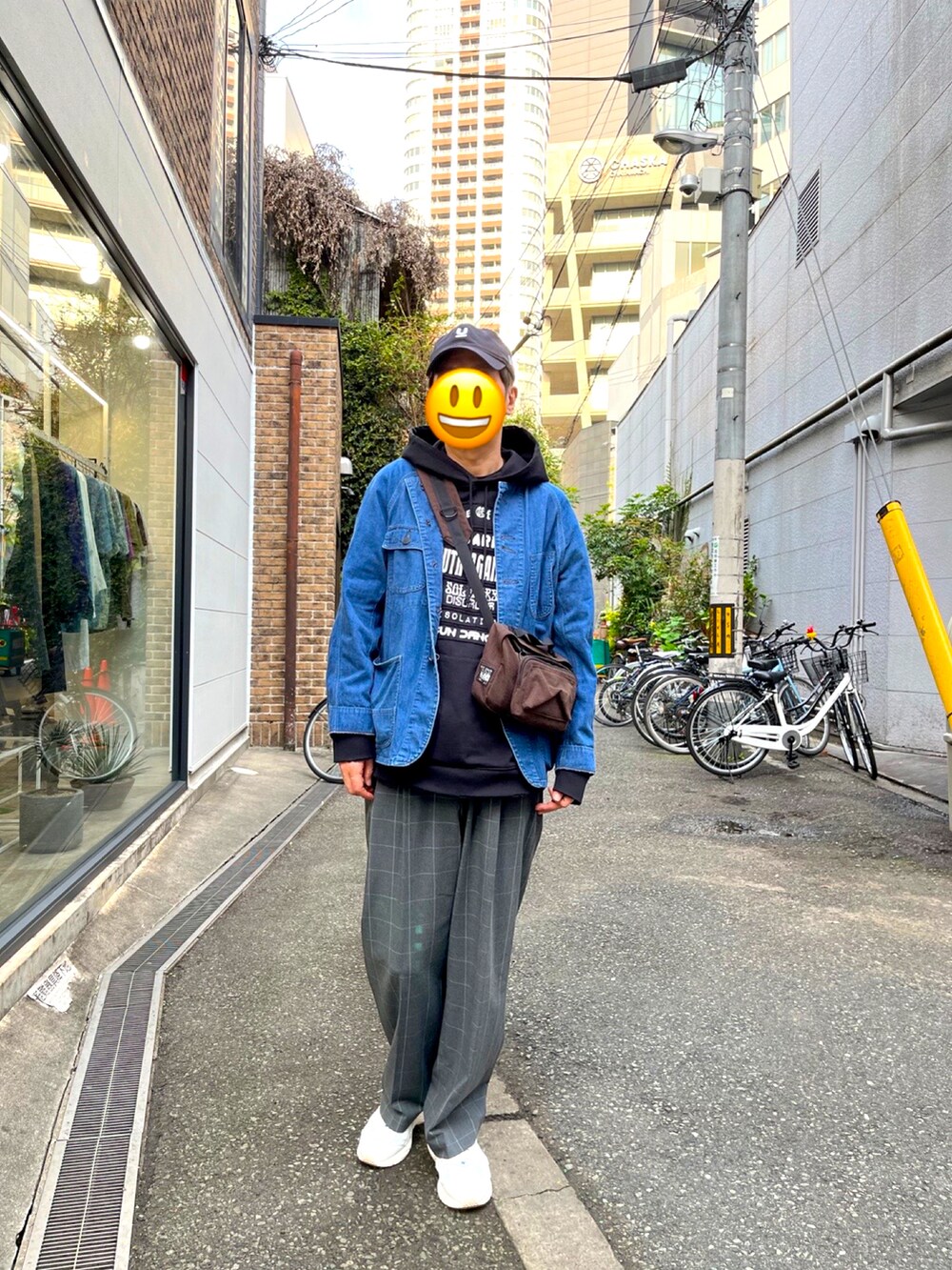 ホワイト系のスニーカー、グレー系のスラックス、ブラウン系のボディバッグ/ウエストポーチを着用したメンズの春コーディネートの2枚目の写真