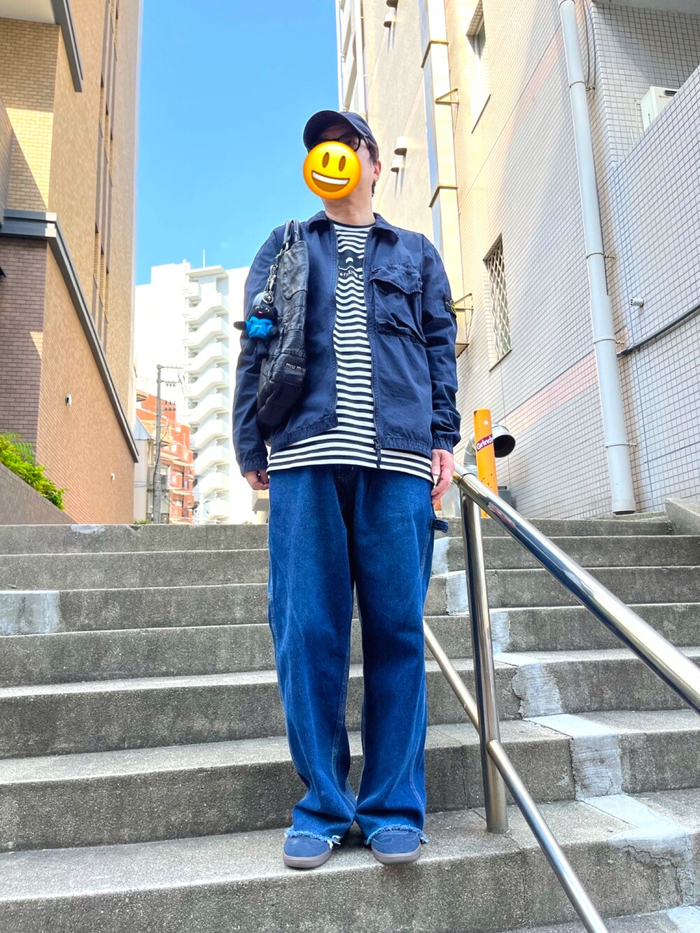 ブルー系のスニーカー、ブルー系のミリタリージャケット、ブラック系のトートバッグを着用したメンズの春コーディネートの2枚目の写真