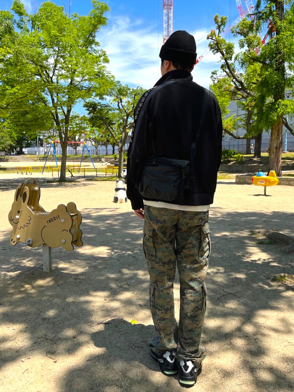 ブラック系のスニーカー、ベージュ系のカーゴパンツ、ブラック系のその他アウターを着用したメンズの春コーディネートの2枚目の写真