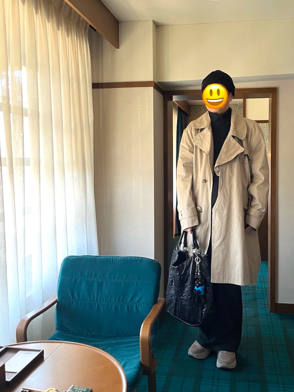 ベージュ系のスニーカー、グレー系のスラックス、ベージュ系のトレンチコートを着用したメンズの春コーディネートの3枚目の写真