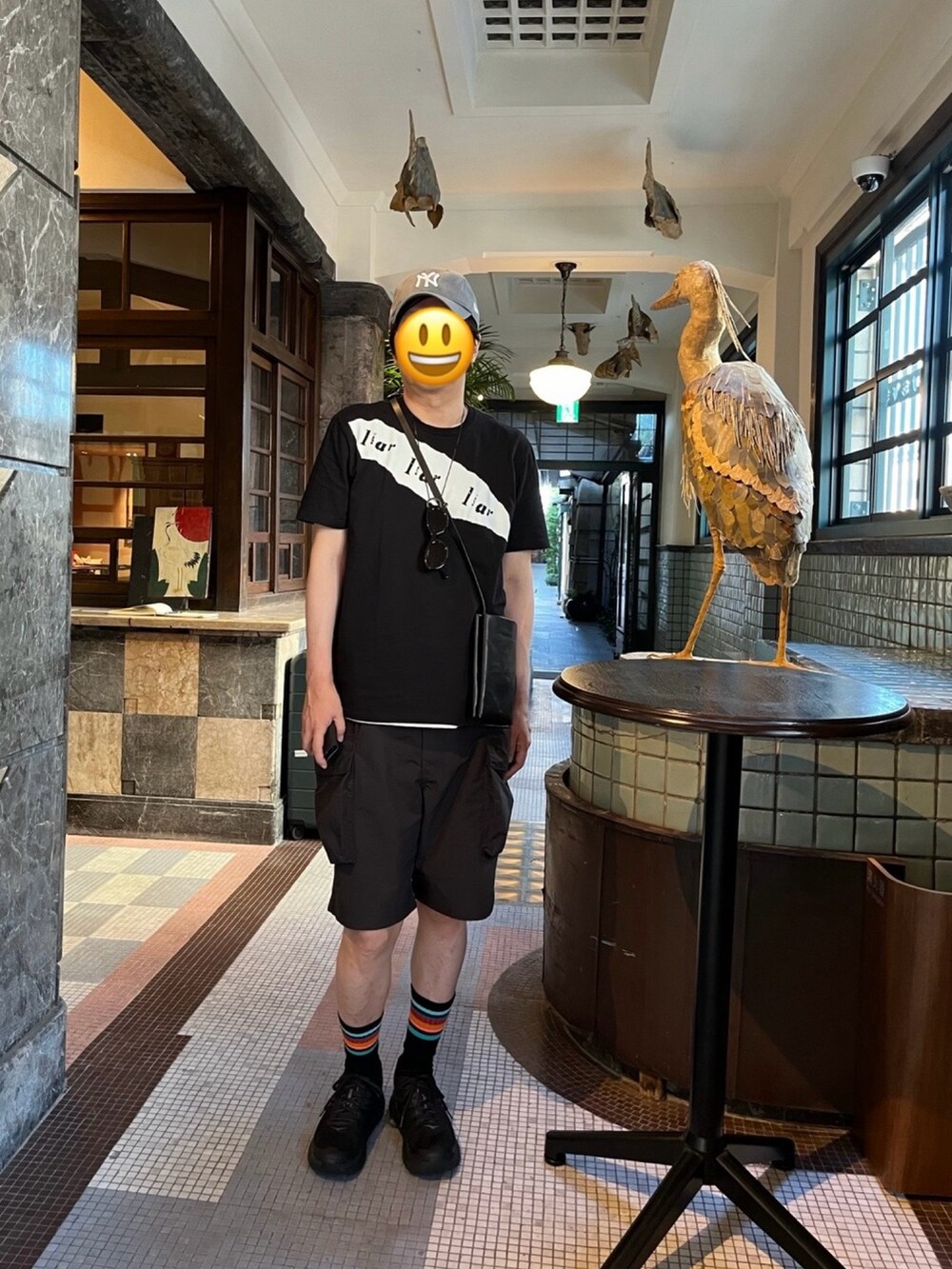 ブラック系のスニーカー、ブラック系のカーゴパンツ、ブラック系のTシャツ/カットソーを着用したメンズの夏コーディネートの2枚目の写真