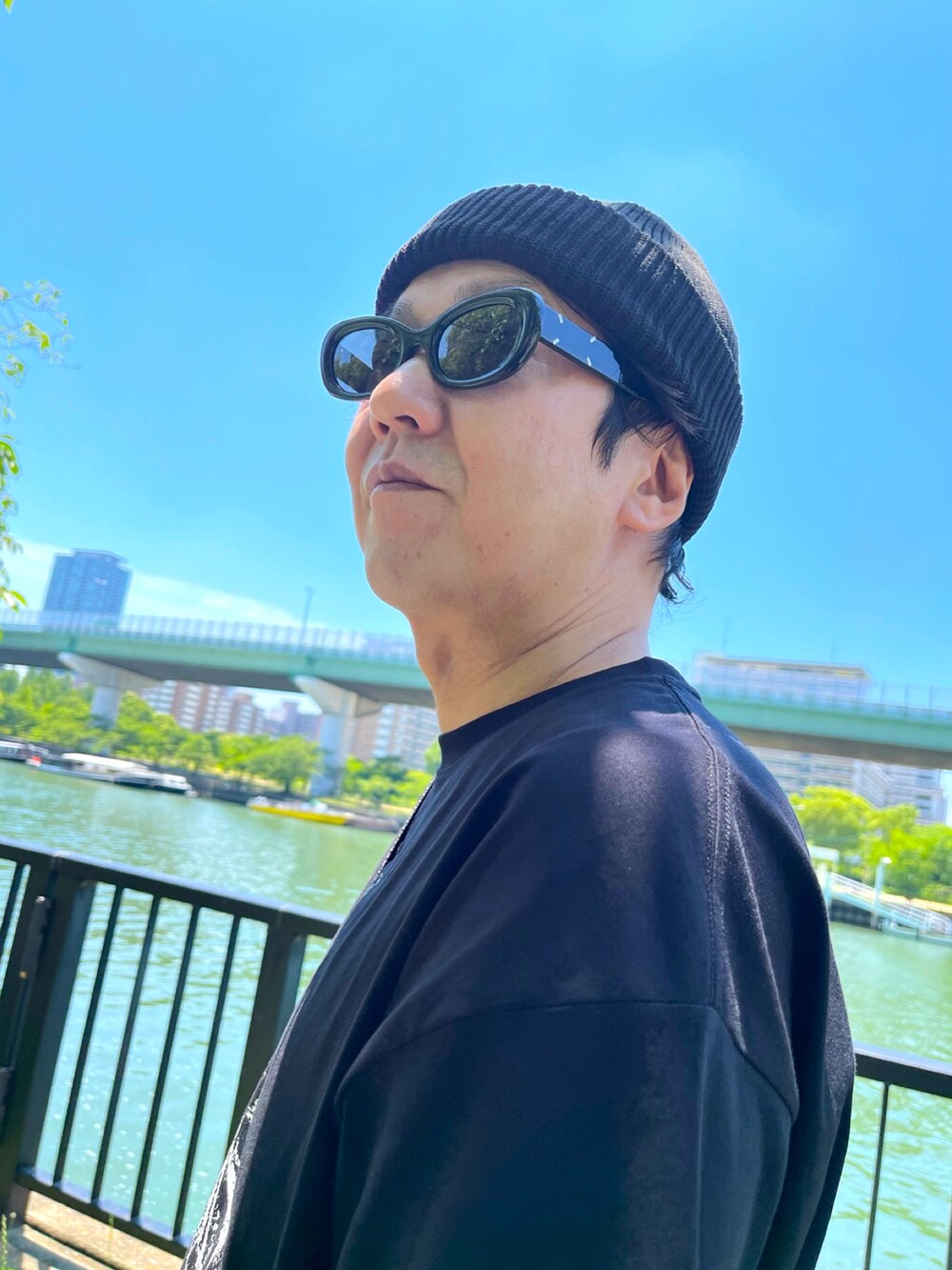 ブラック系のスニーカー、グレー系のスウェットパンツ、ブラック系のTシャツ/カットソーを着用したメンズの夏コーディネートの2枚目の写真