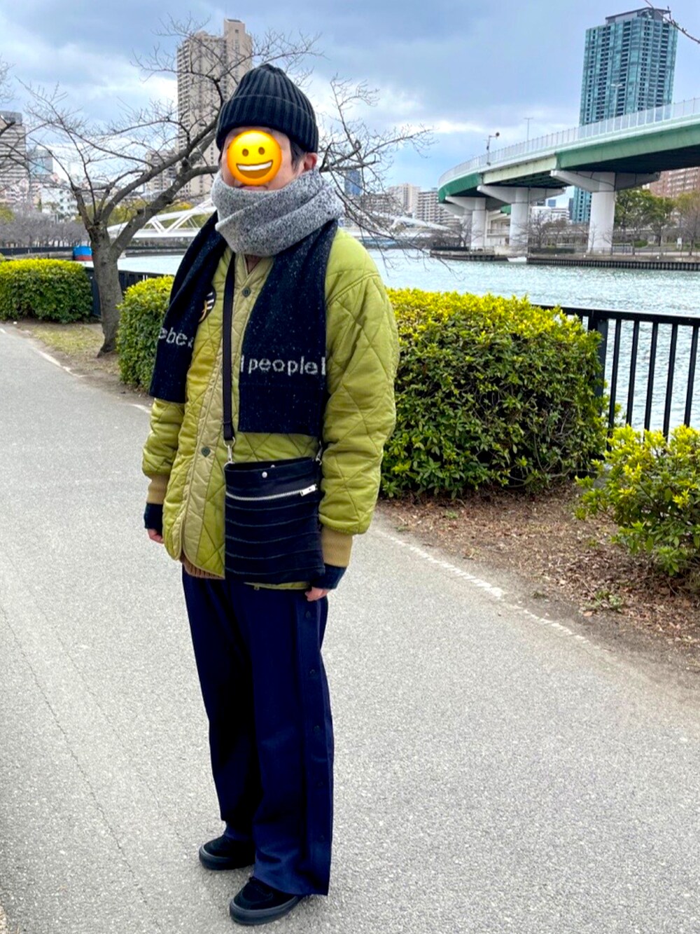 ブラック系のスニーカー、ブルー系のその他パンツ、グリーン系のミリタリージャケットを着用したメンズの春コーディネートの2枚目の写真