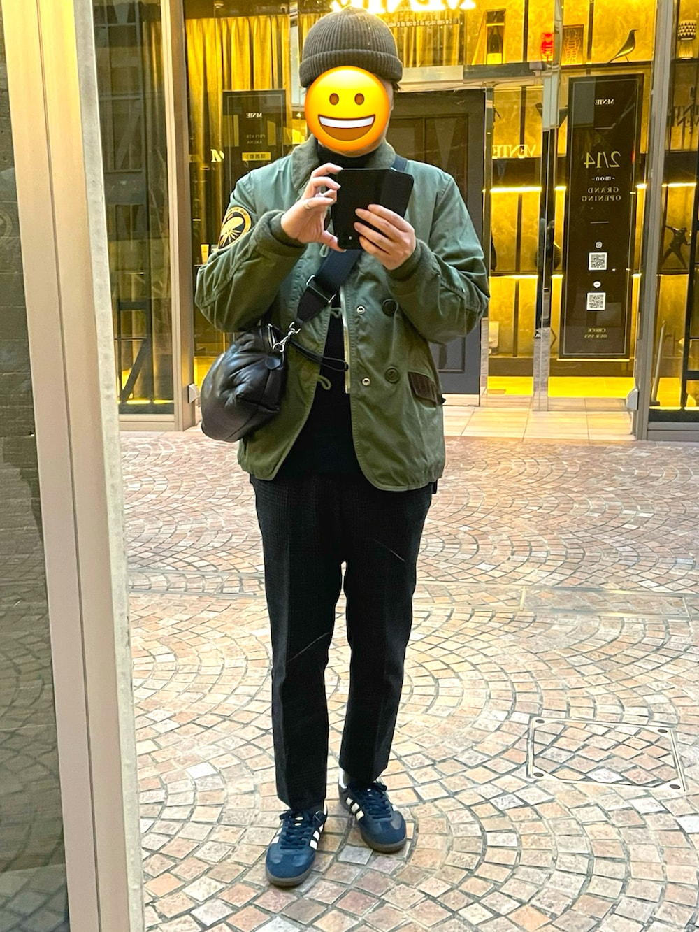 ブルー系のスニーカー、ブラック系のスラックス、ブラック系のショルダーバッグを着用したメンズの冬コーディネートの3枚目の写真