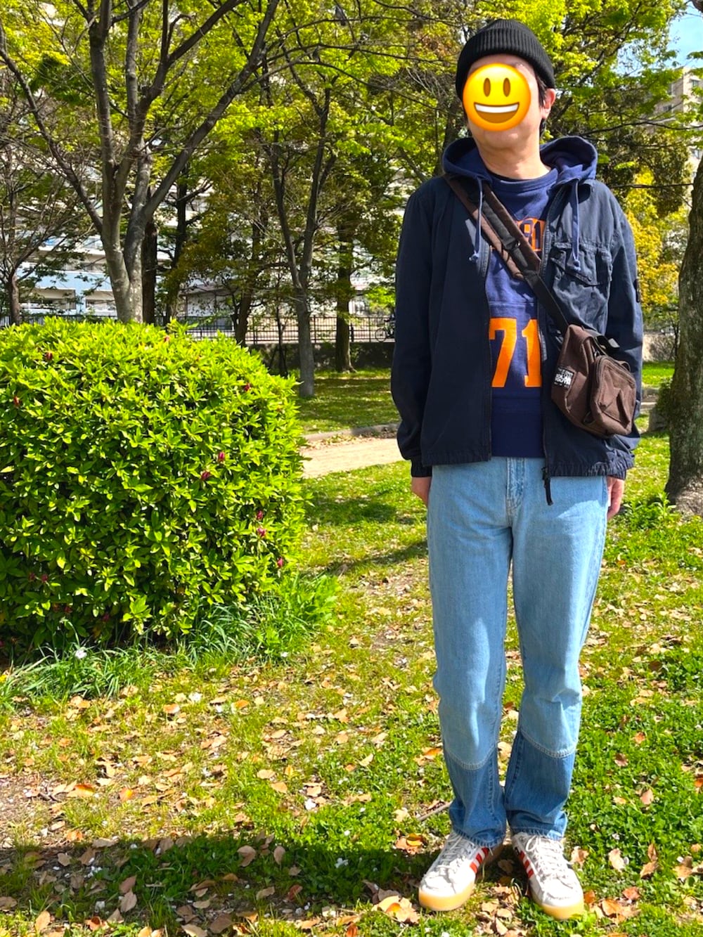 ホワイト系のスニーカー、ブルー系のデニムパンツ、ブラウン系のショルダーバッグを着用したメンズの春コーディネートの2枚目の写真