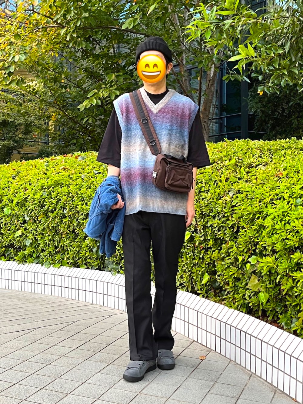 グレー系のスニーカー、ブラック系のスラックス、ブルー系のデニムジャケットを着用したメンズの秋コーディネートの2枚目の写真