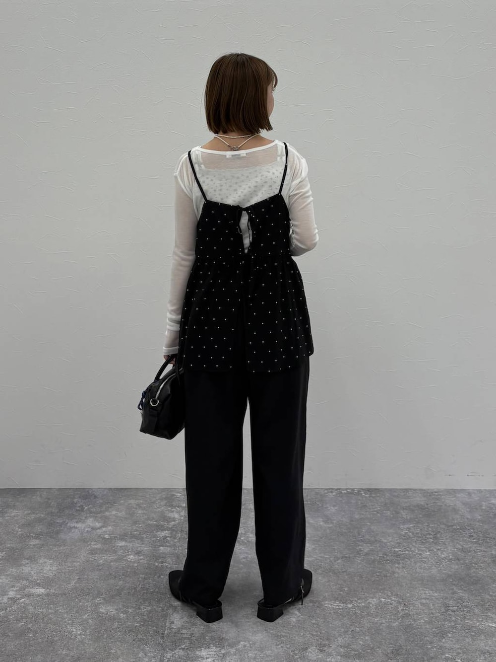 ブラック系のボストンバッグ、ブルー系のベスト、ブラック系のパンプスを着用したレディースの春コーディネートの3枚目の写真