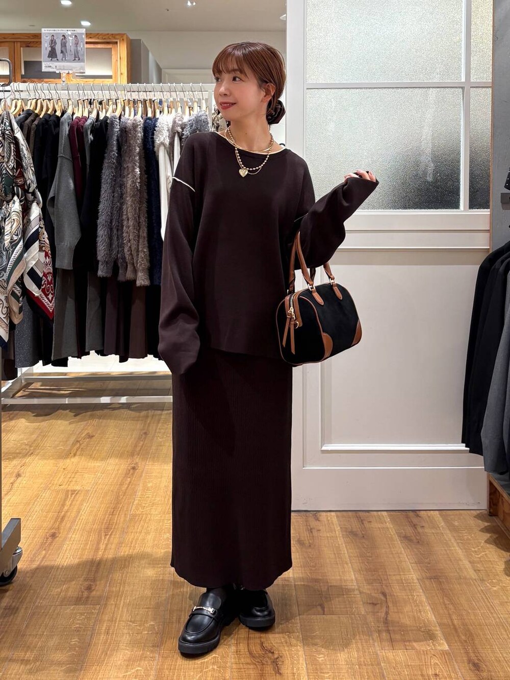 ブラック系のローファー、ブラウン系のワンピース、ブラック系のボストンバッグを着用したレディースの秋コーディネートの5枚目の写真