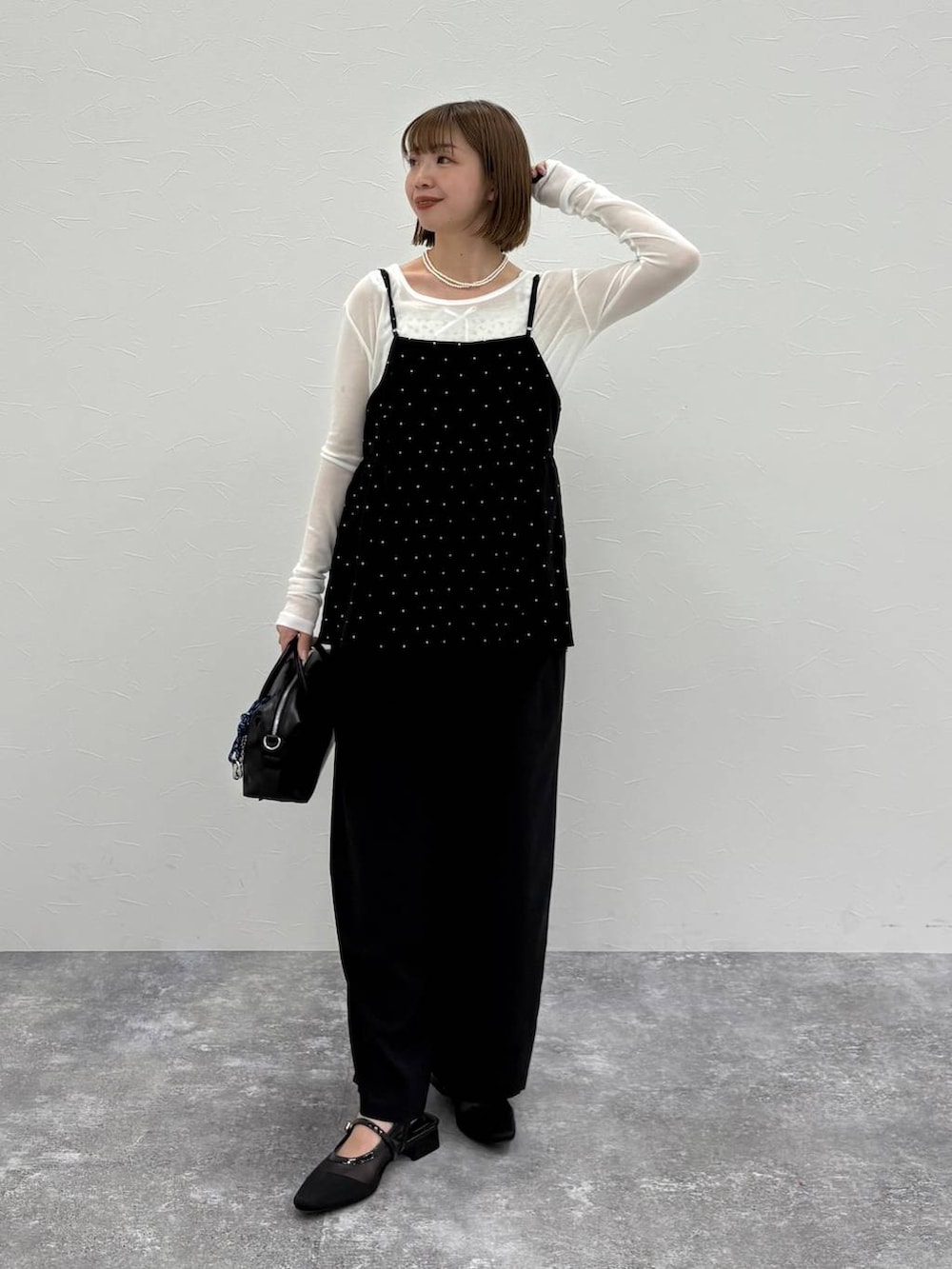 ブラック系のボストンバッグ、ブルー系のベスト、ブラック系のパンプスを着用したレディースの春コーディネートの5枚目の写真