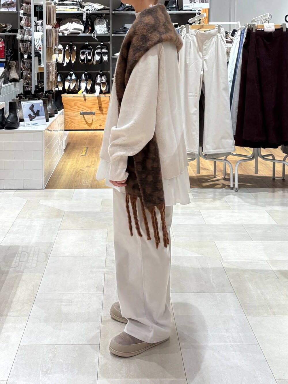 グレー系のその他パンツ、ホワイト系のTシャツ/カットソー、ホワイト系のニット/セーターを着用したレディースの秋コーディネートの2枚目の写真