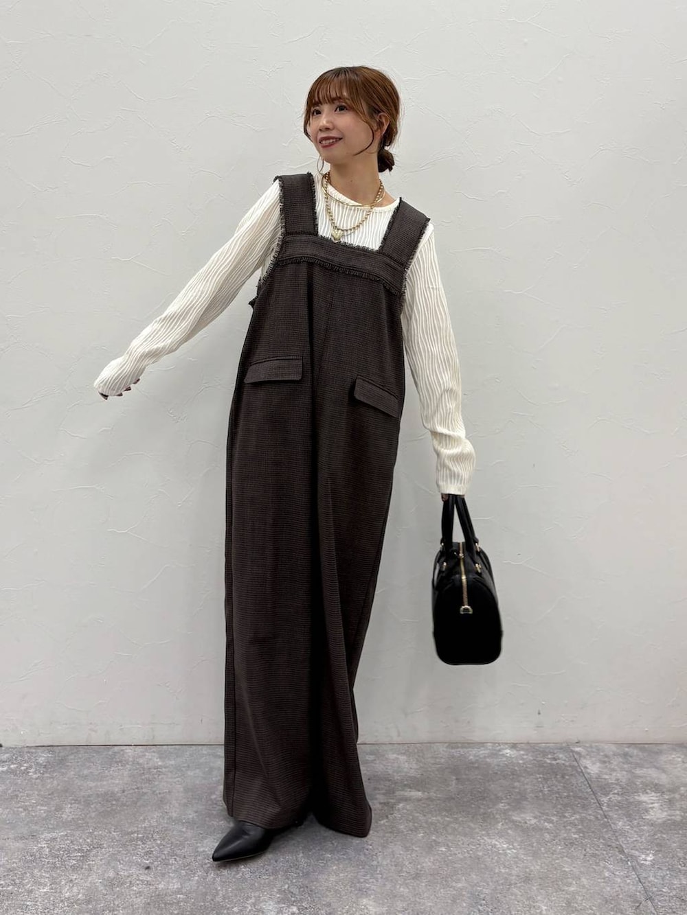 ベージュ系のTシャツ/カットソー、ベージュ系のカーディガン/ボレロ、ブラック系のボストンバッグを着用したレディースの冬コーディネートの7枚目の写真