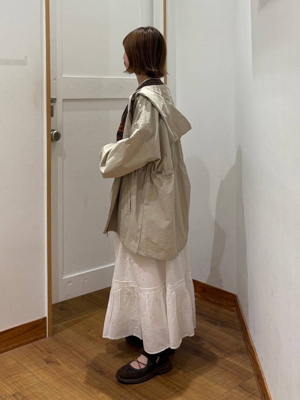 ベージュ系のパーカー、ホワイト系のスカート、ブラウン系のTシャツ/カットソーを着用したレディースの春コーディネートの2枚目の写真