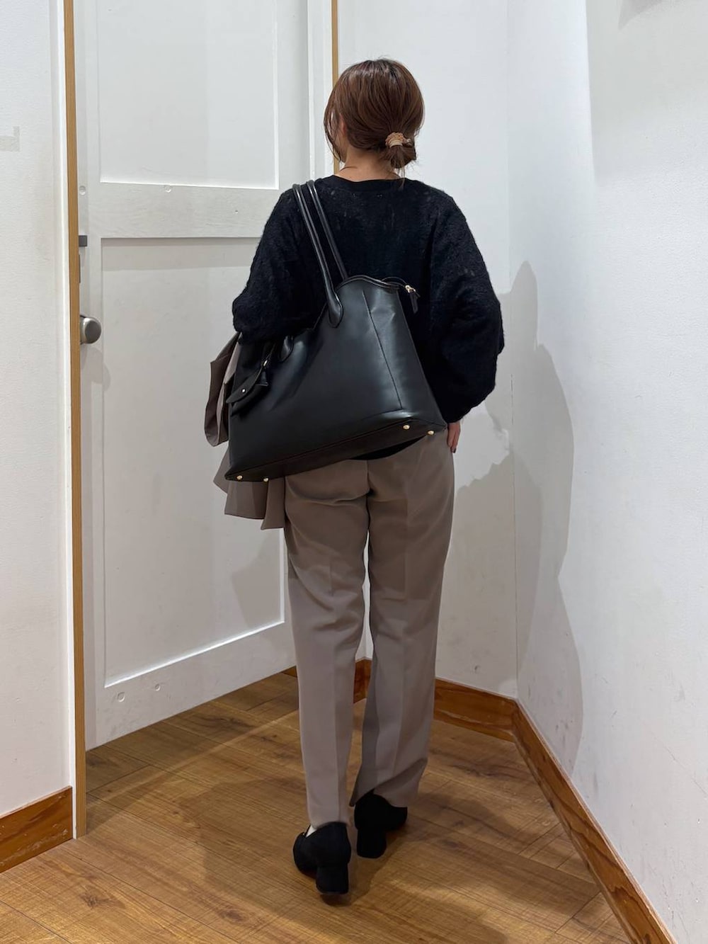 ブラック系のローファー、ブラック系のトートバッグ、ブラウン系のスラックスを着用したレディースの秋コーディネートの3枚目の写真