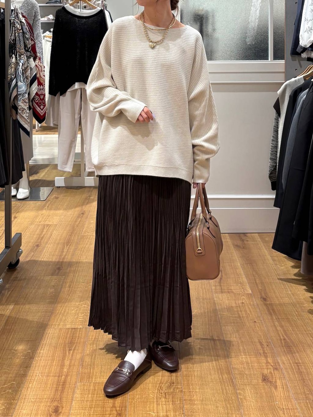 ブラウン系のローファー、グレー系のニット/セーター、ベージュ系のボストンバッグを着用したレディースの秋コーディネートの6枚目の写真