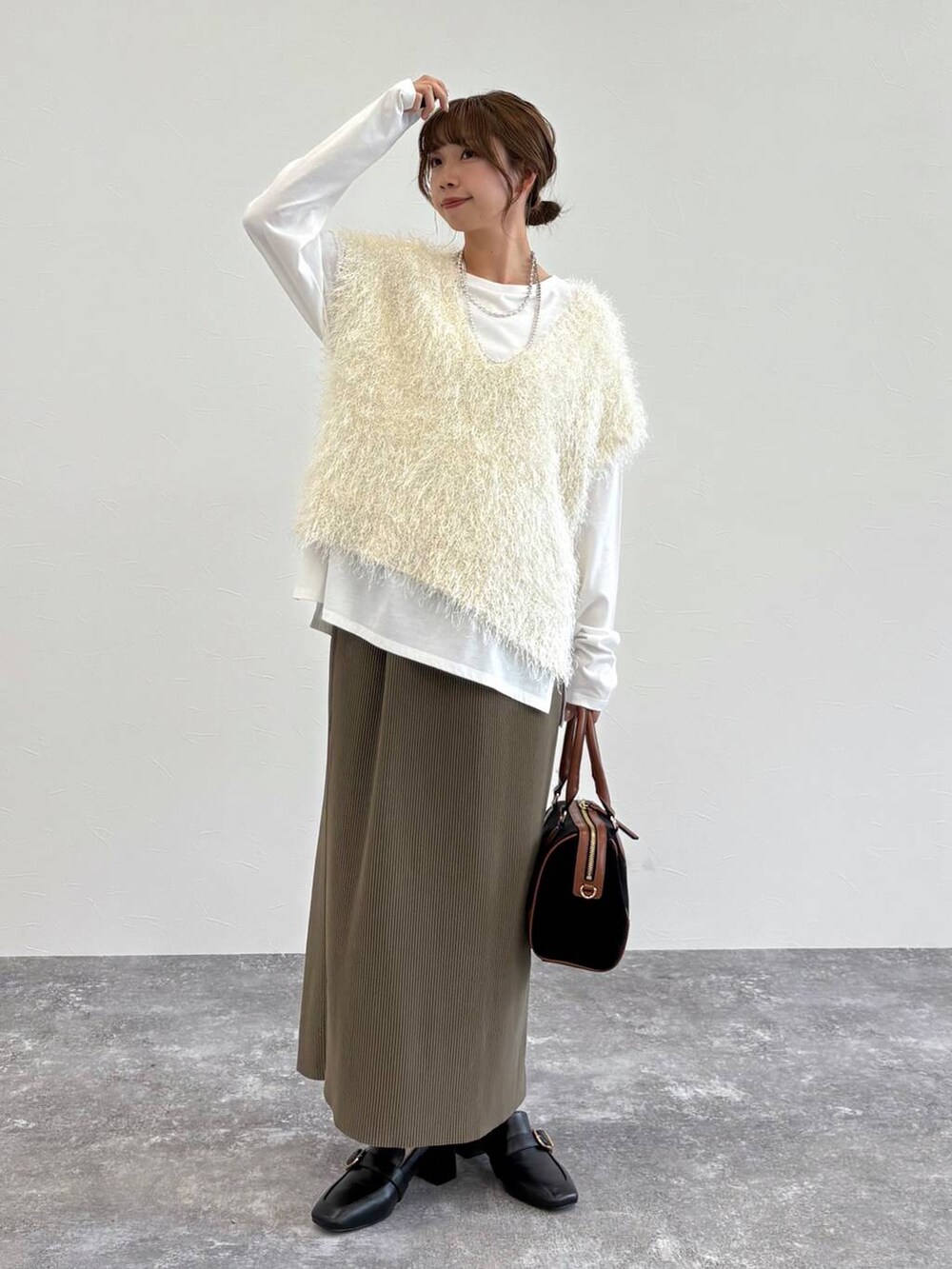 ブラック系のローファー、ベージュ系のタンクトップ、グリーン系のスカートを着用したレディースの夏コーディネートの6枚目の写真