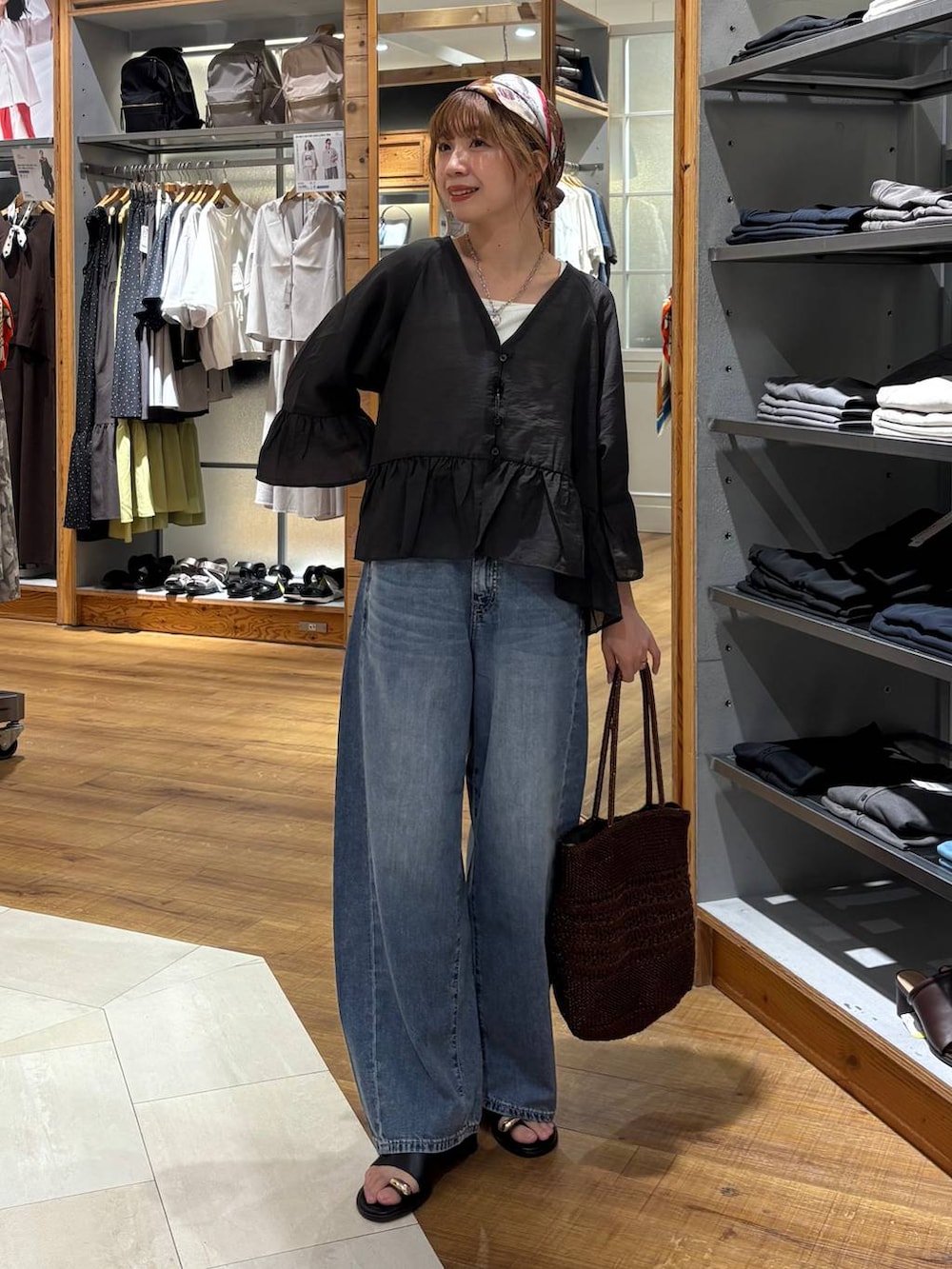 ブルー系のデニムパンツ、ホワイト系のタンクトップ、ブラウン系のクラッチバッグを着用したレディースの夏コーディネートの8枚目の写真