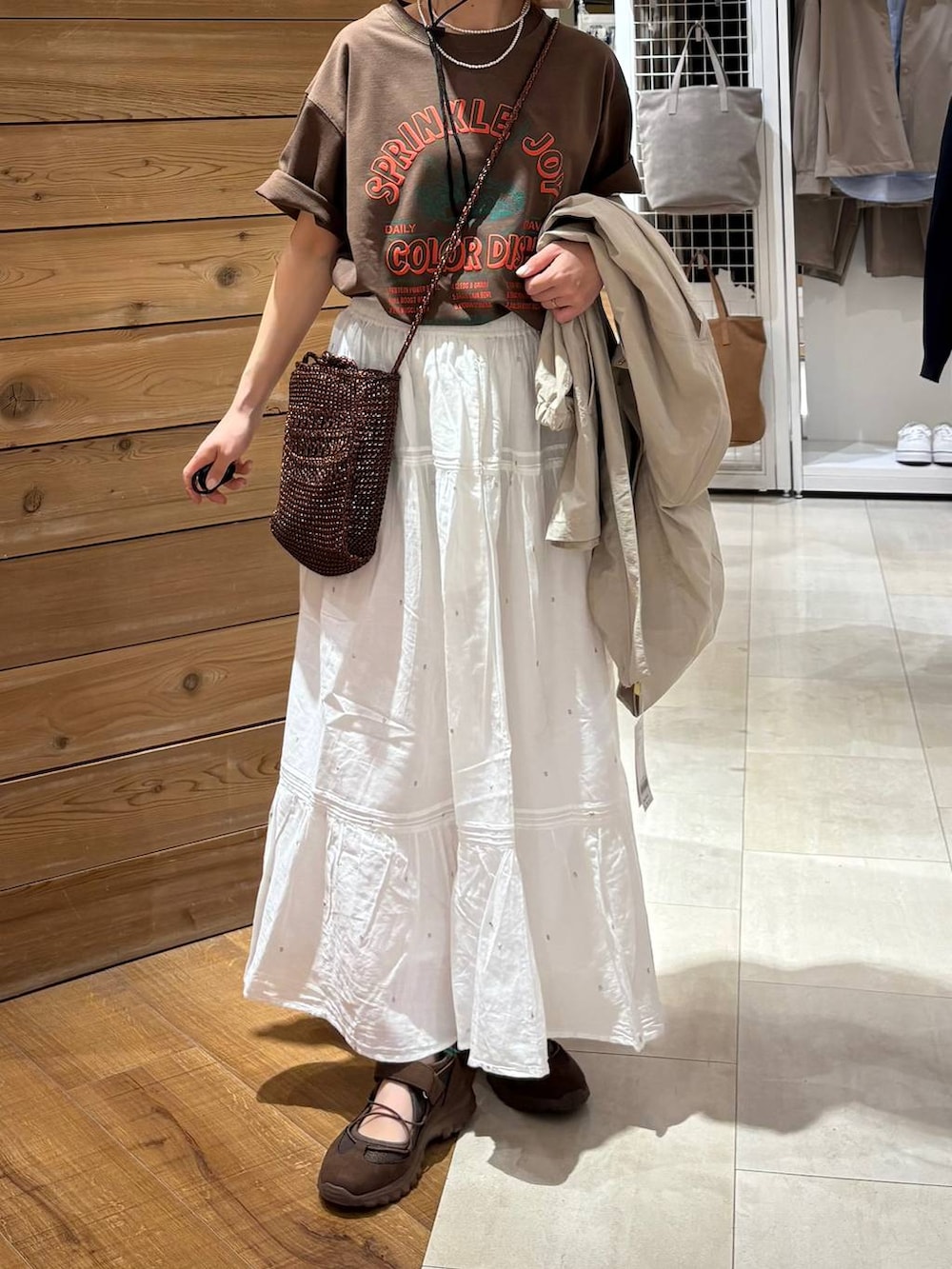 ベージュ系のパーカー、ホワイト系のスカート、ブラウン系のTシャツ/カットソーを着用したレディースの春コーディネートの7枚目の写真