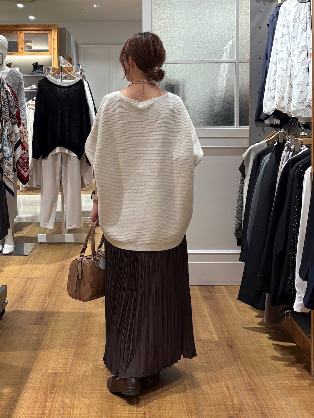 ブラウン系のローファー、グレー系のニット/セーター、ベージュ系のボストンバッグを着用したレディースの秋コーディネートの3枚目の写真