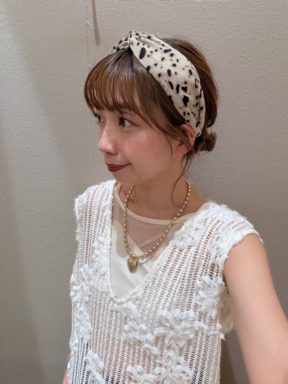 ホワイト系のTシャツ/カットソー、ベージュ系のヘアゴム、ゴールド系のネックレスを着用したレディースの秋コーディネートの4枚目の写真