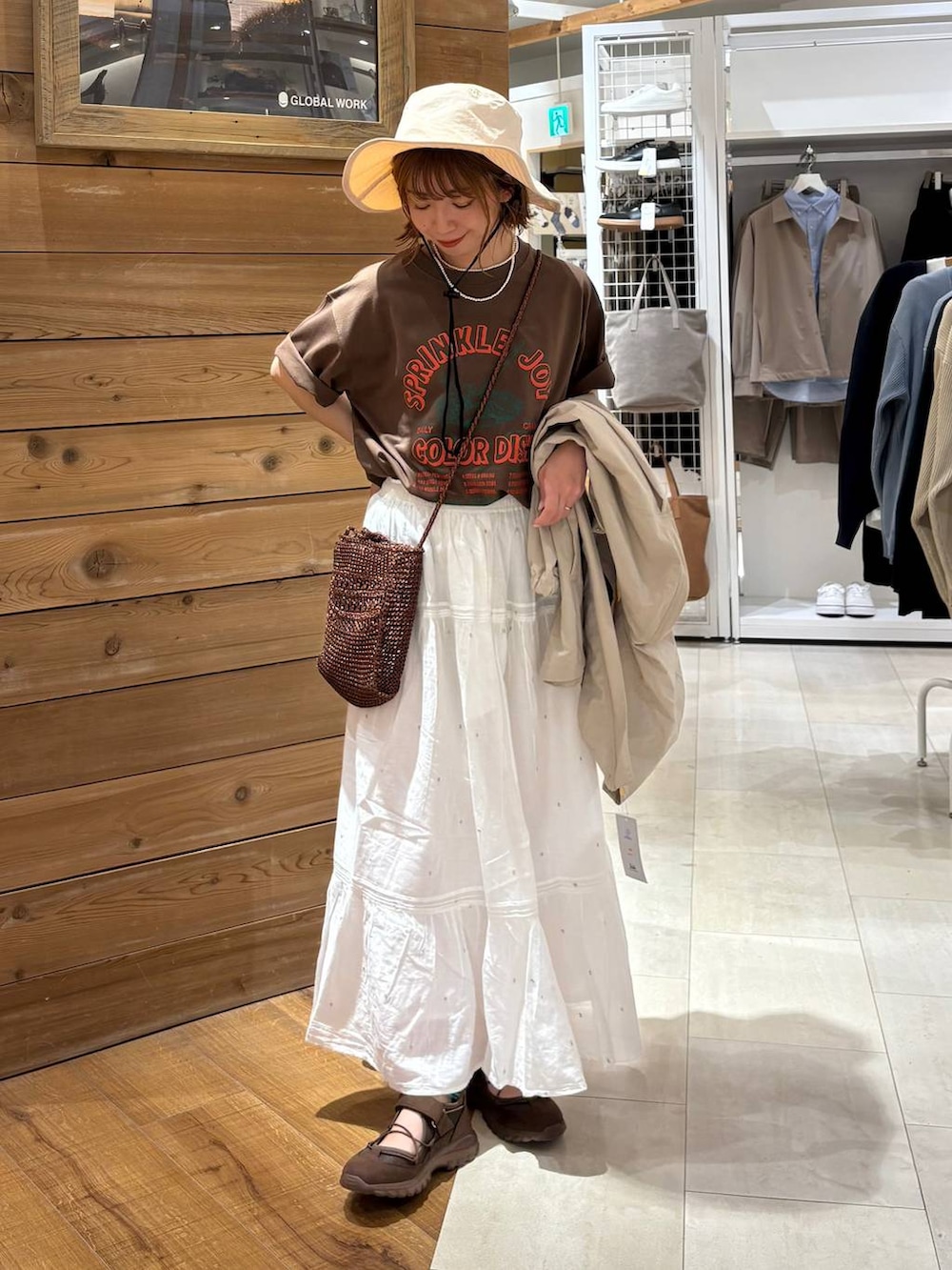 ベージュ系のパーカー、ホワイト系のスカート、ブラウン系のTシャツ/カットソーを着用したレディースの春コーディネートの5枚目の写真