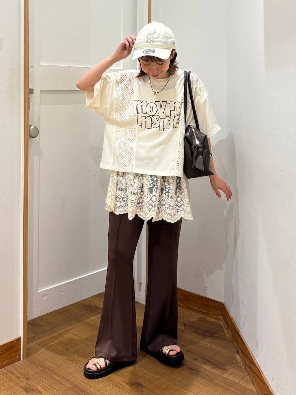 ブラウン系のボストンバッグ、ブラウン系のサンダル、ベージュ系のTシャツ/カットソーを着用したレディースの夏コーディネートの5枚目の写真