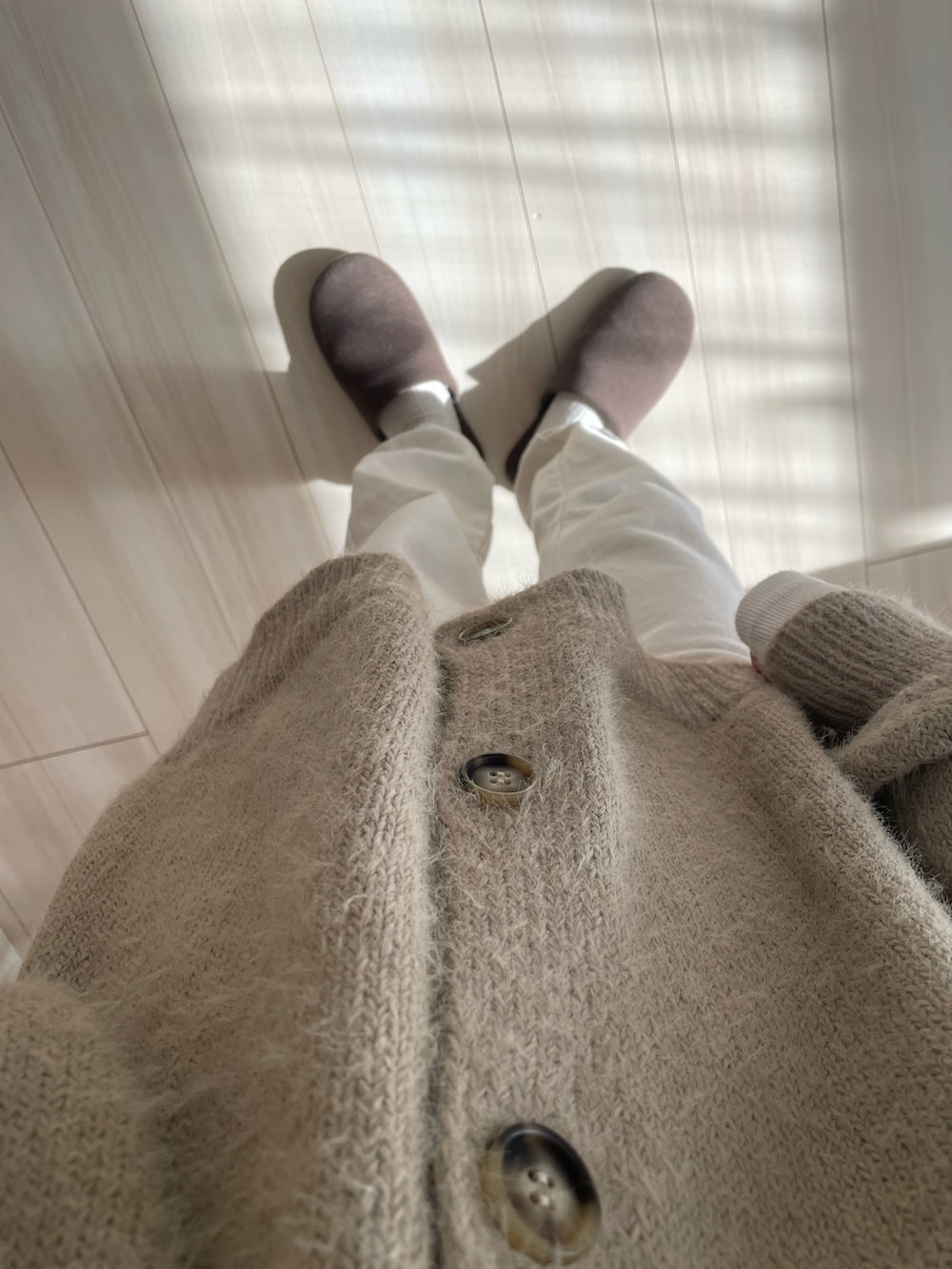 ホワイト系のスウェットパンツ、ベージュ系のカーディガン/ボレロを着用したレディースの冬コーディネートの3枚目の写真