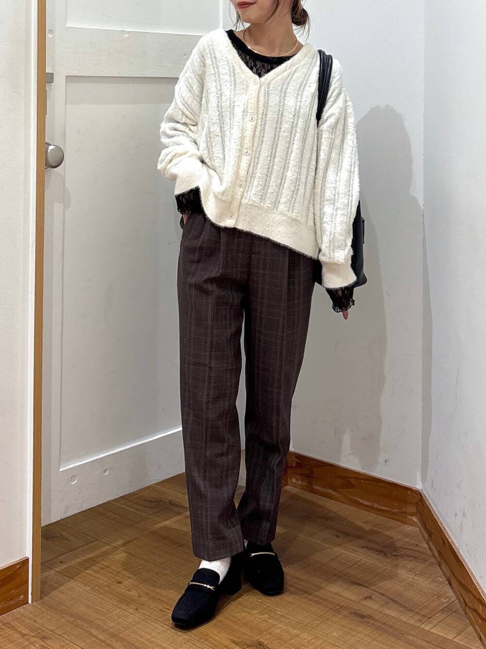 ブラック系のローファー、ブラック系のトートバッグ、ホワイト系のカーディガン/ボレロを着用したレディースの秋コーディネートの4枚目の写真