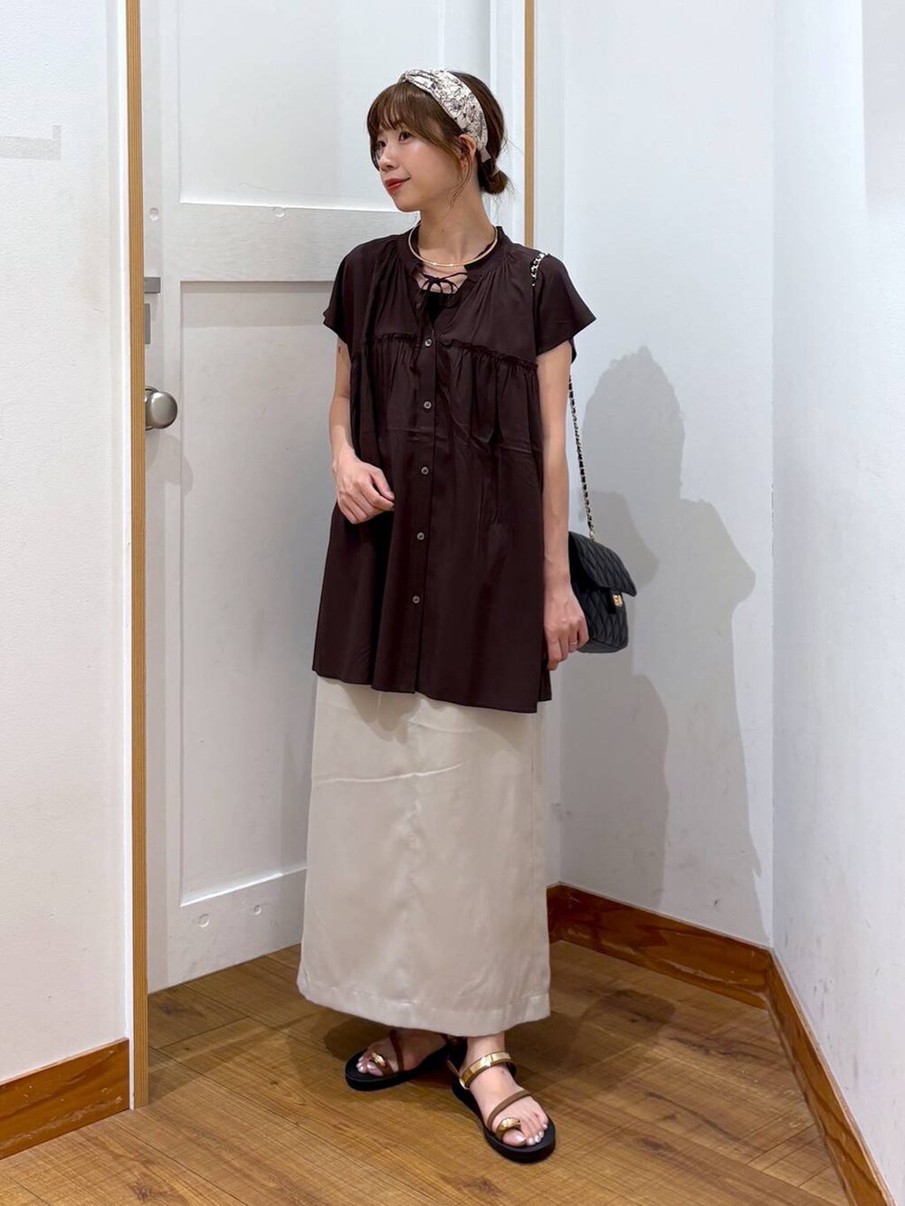 ブラック系のショルダーバッグ、ブラック系のタンクトップ、グレー系のスカートを着用したレディースの夏コーディネートの5枚目の写真