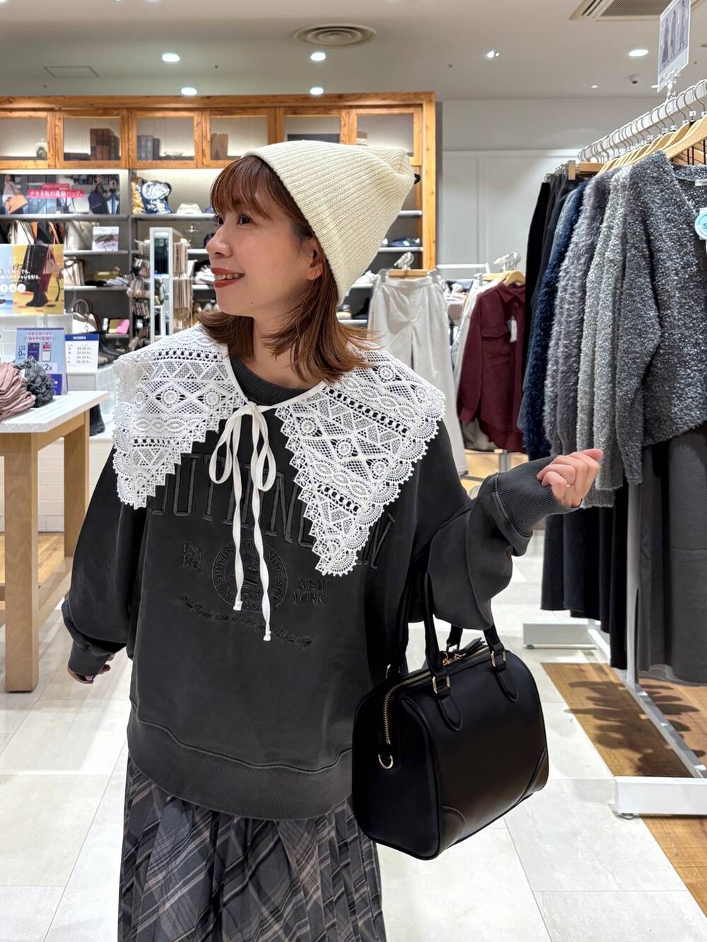 ブラック系のブーツ、グレー系のスカート、ブラック系のボストンバッグを着用したレディースの秋コーディネートの7枚目の写真