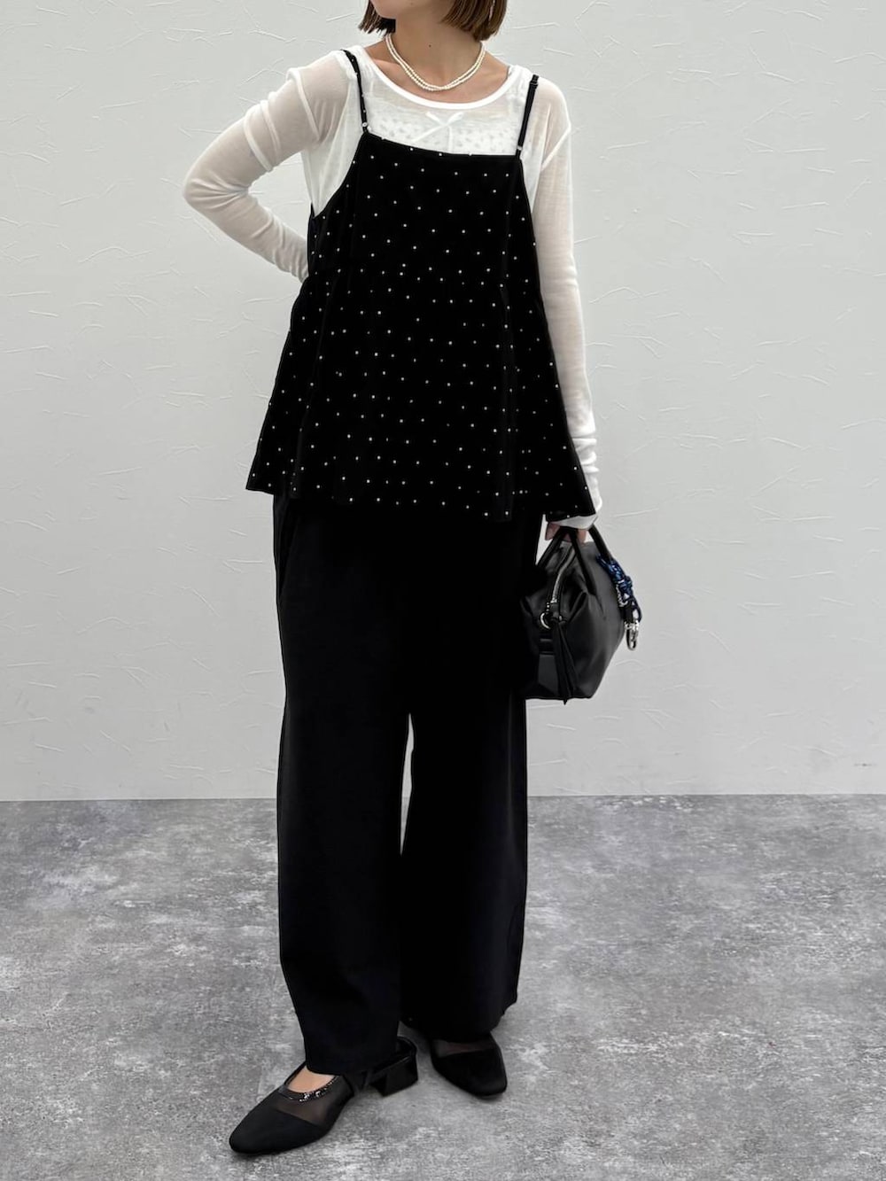 ブラック系のボストンバッグ、ブルー系のベスト、ブラック系のパンプスを着用したレディースの春コーディネートの4枚目の写真