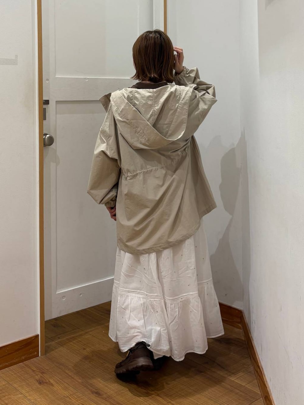 ベージュ系のパーカー、ホワイト系のスカート、ブラウン系のTシャツ/カットソーを着用したレディースの春コーディネートの3枚目の写真