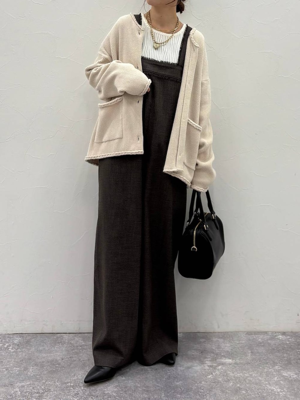 ベージュ系のTシャツ/カットソー、ベージュ系のカーディガン/ボレロ、ブラック系のボストンバッグを着用したレディースの冬コーディネートの5枚目の写真