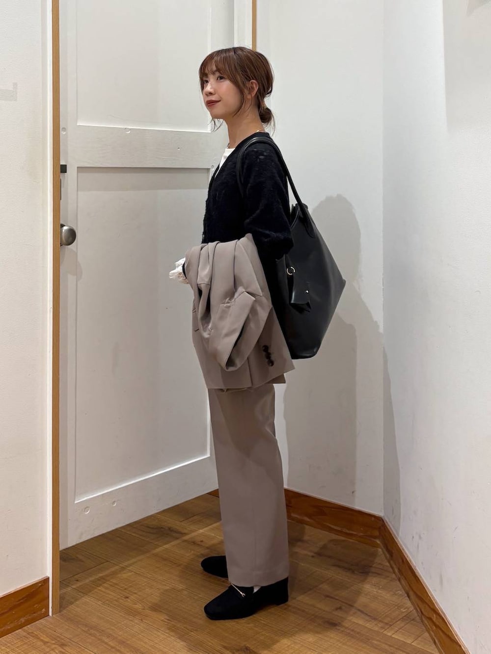 ブラック系のローファー、ブラック系のトートバッグ、ブラウン系のスラックスを着用したレディースの秋コーディネートの2枚目の写真