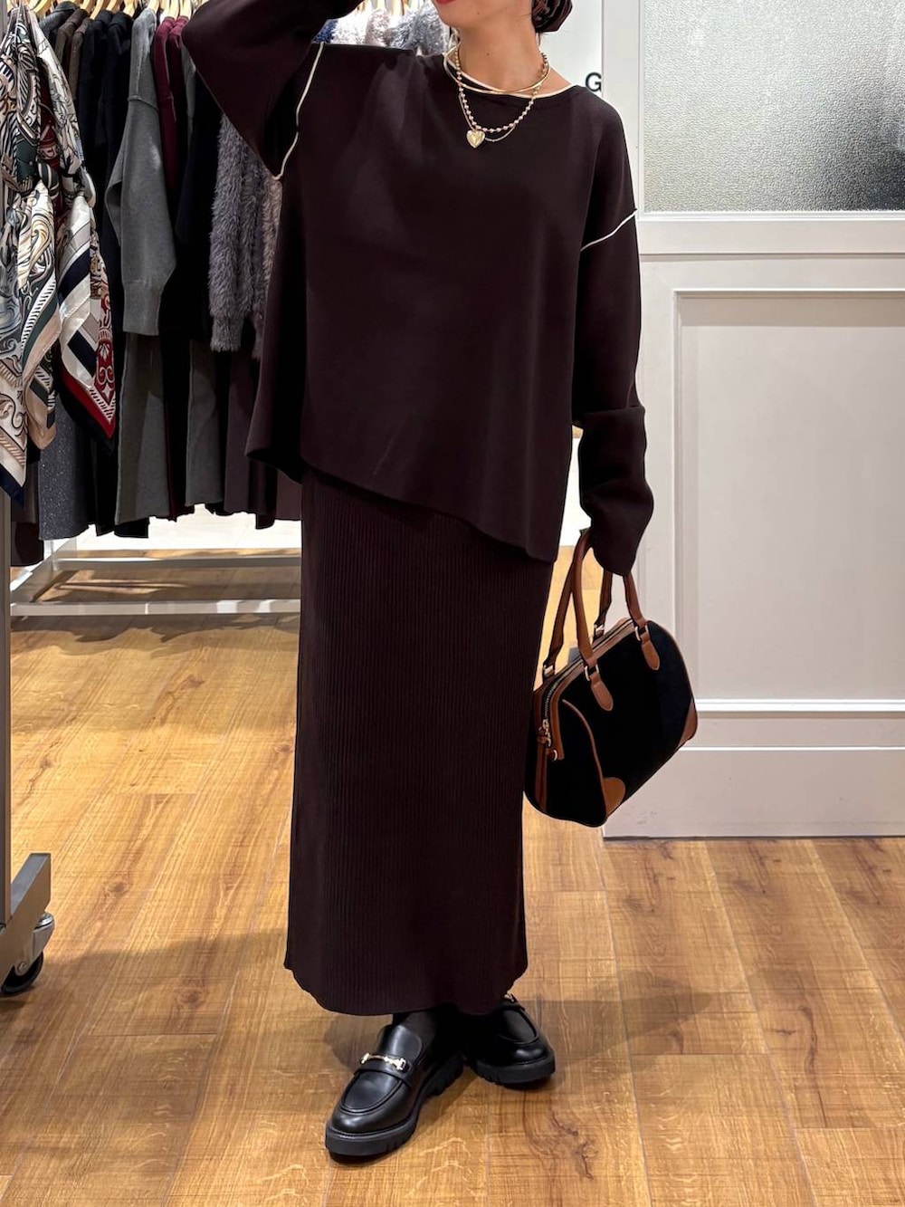 ブラック系のローファー、ブラウン系のワンピース、ブラック系のボストンバッグを着用したレディースの秋コーディネートの3枚目の写真