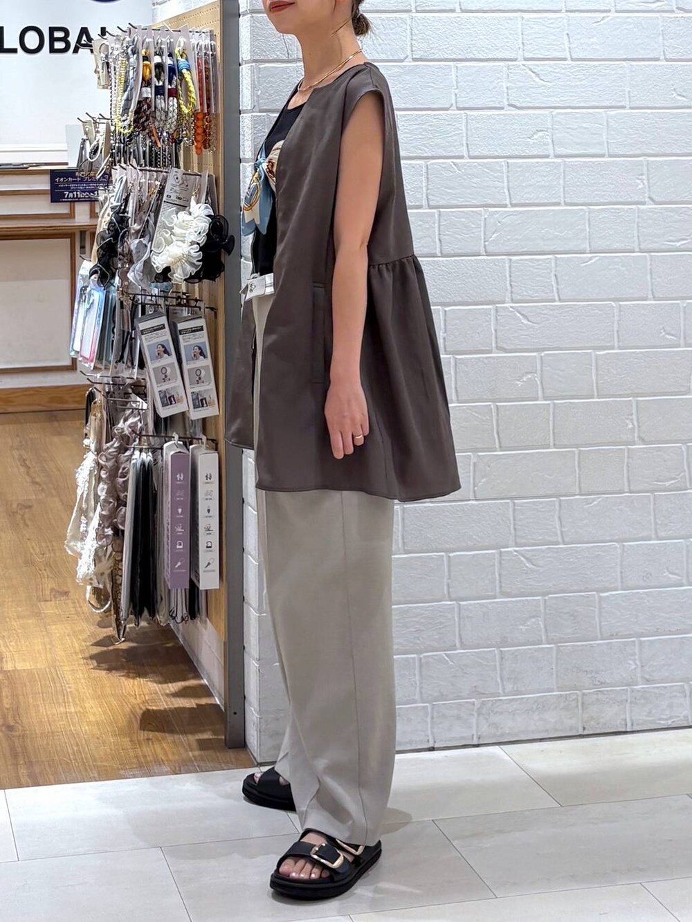 ブラック系のタンクトップ、ベージュ系のその他パンツ、ブラウン系のベストを着用したレディースの夏コーディネートの2枚目の写真