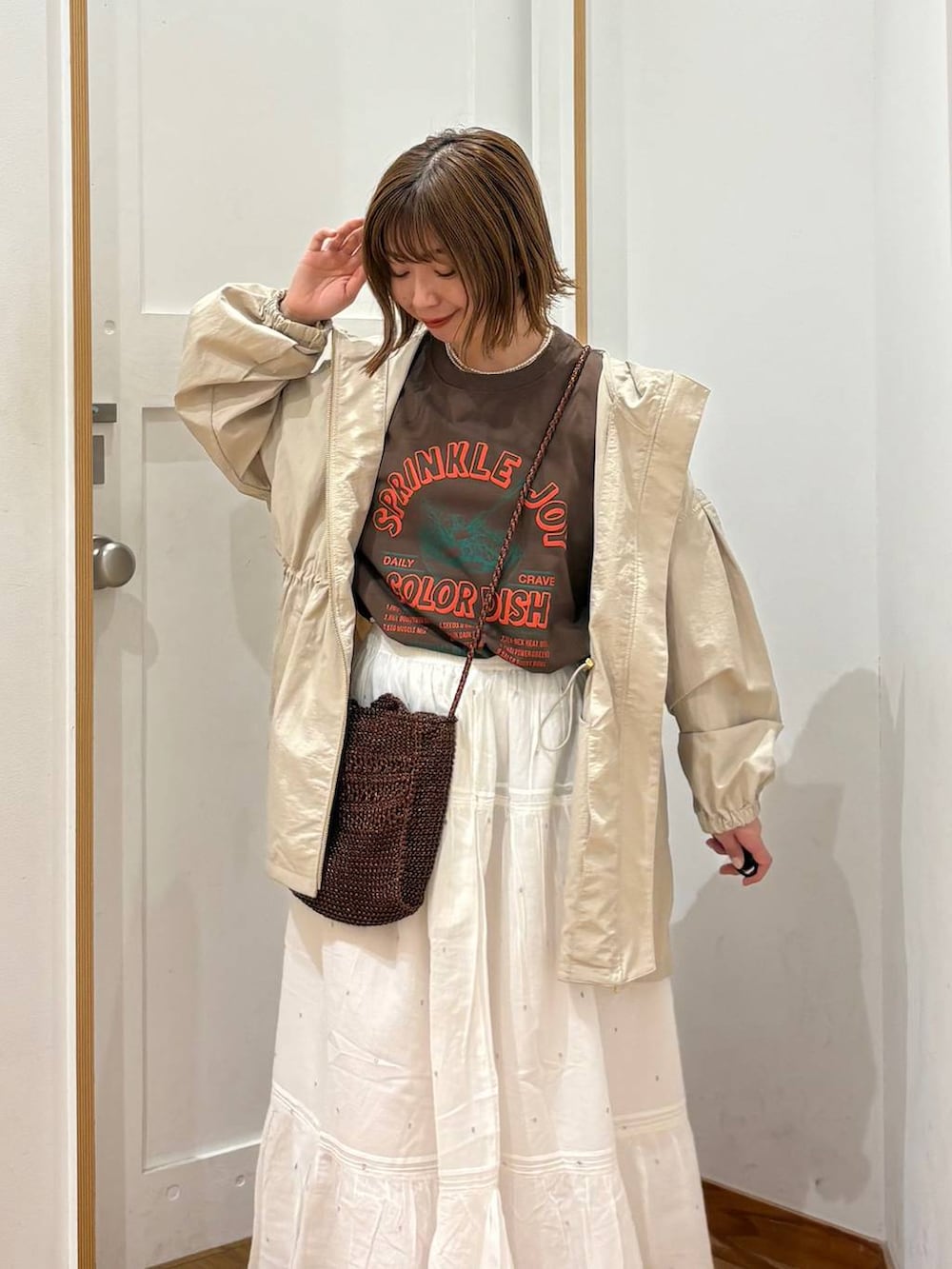 ベージュ系のパーカー、ホワイト系のスカート、ブラウン系のTシャツ/カットソーを着用したレディースの春コーディネートの6枚目の写真