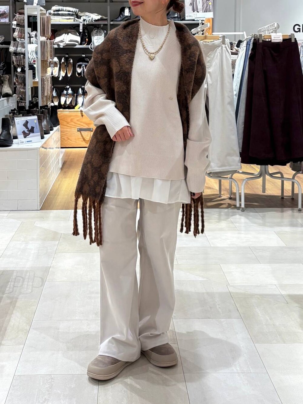 グレー系のその他パンツ、ホワイト系のTシャツ/カットソー、ホワイト系のニット/セーターを着用したレディースの秋コーディネートの4枚目の写真