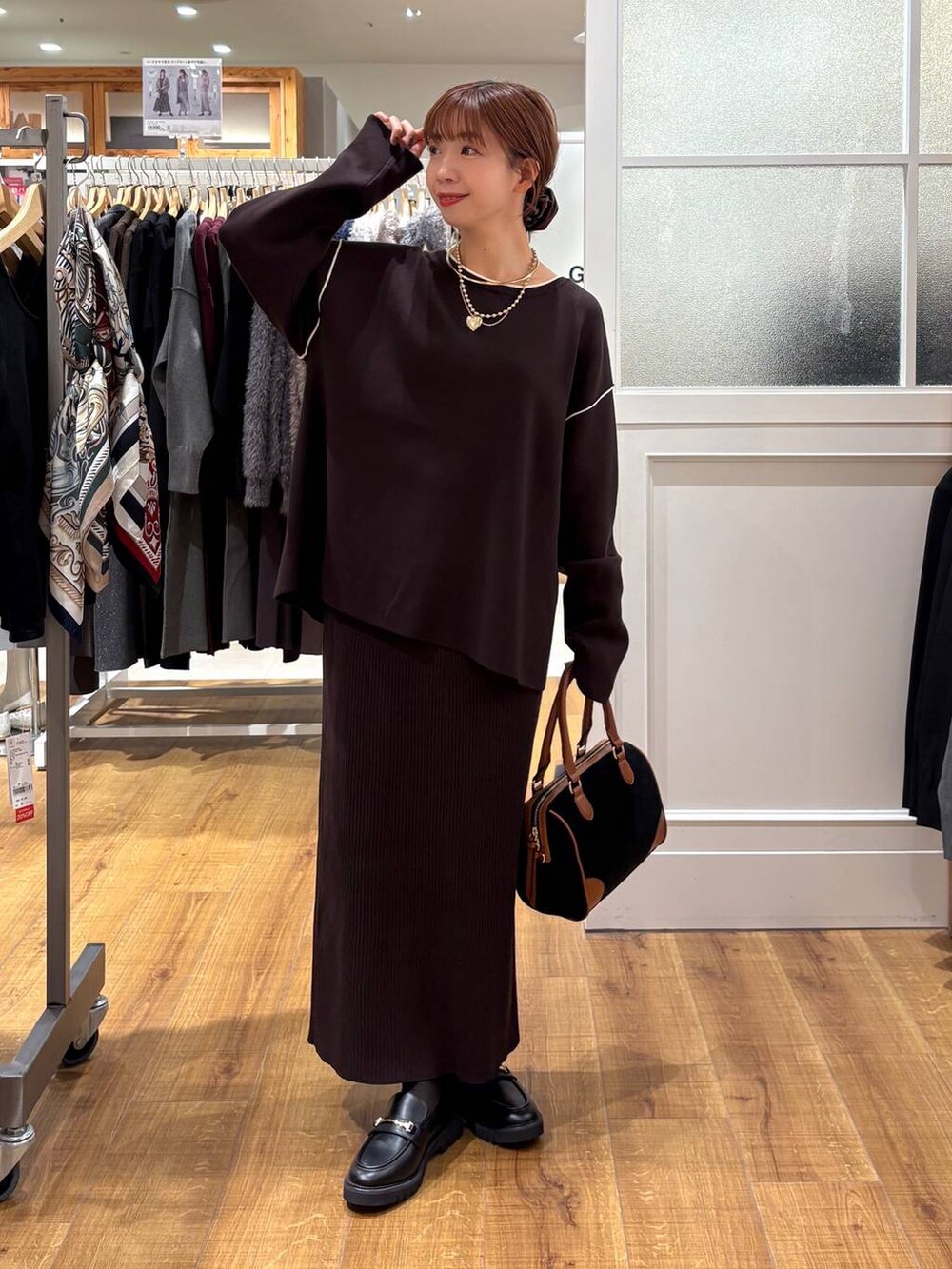 ブラック系のローファー、ブラウン系のワンピース、ブラック系のボストンバッグを着用したレディースの秋コーディネートの4枚目の写真