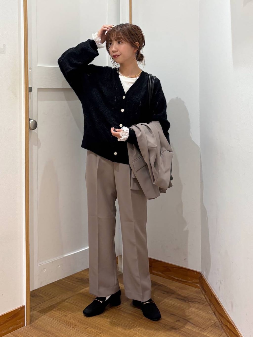 ブラック系のローファー、ブラック系のトートバッグ、ブラウン系のスラックスを着用したレディースの秋コーディネートの5枚目の写真