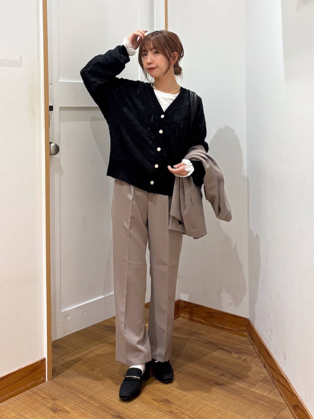 ブラック系のローファー、ブラック系のトートバッグ、ブラウン系のスラックスを着用したレディースの秋コーディネートの6枚目の写真