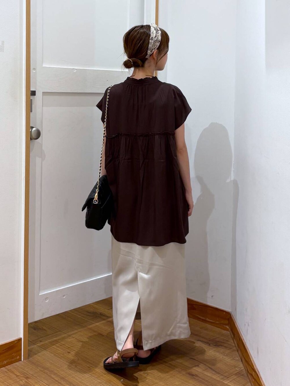 ブラック系のショルダーバッグ、ブラック系のタンクトップ、グレー系のスカートを着用したレディースの夏コーディネートの3枚目の写真