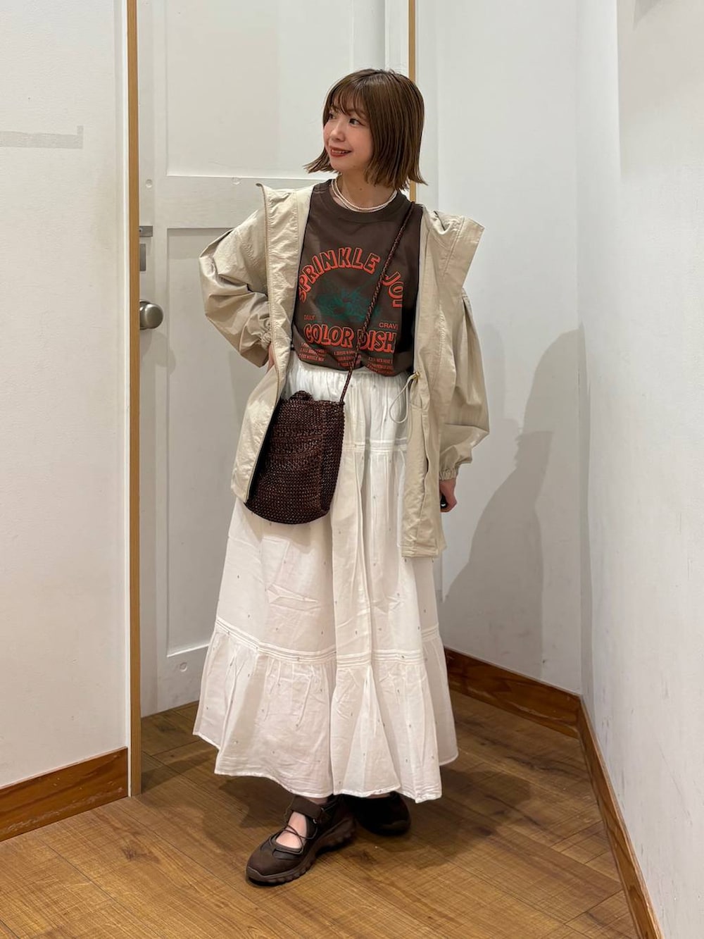 ベージュ系のパーカー、ホワイト系のスカート、ブラウン系のTシャツ/カットソーを着用したレディースの春コーディネートの4枚目の写真