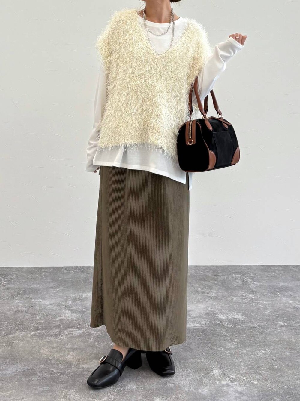 ブラック系のローファー、ベージュ系のタンクトップ、グリーン系のスカートを着用したレディースの夏コーディネートの4枚目の写真