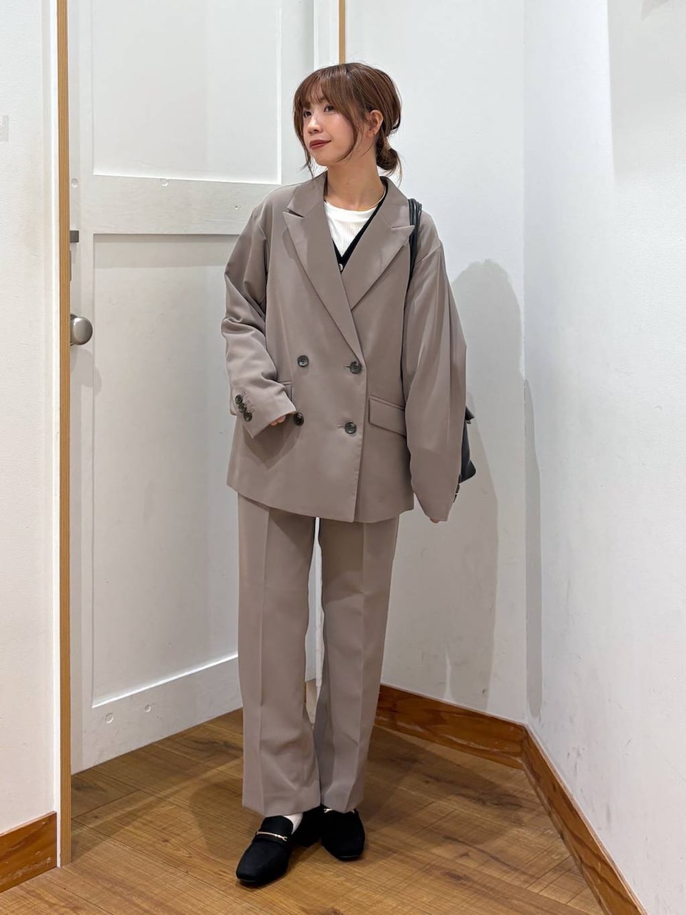 ブラック系のローファー、ブラック系のトートバッグ、ブラウン系のスラックスを着用したレディースの秋コーディネートの9枚目の写真