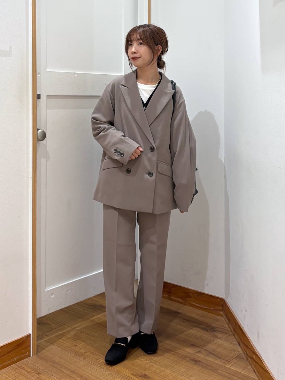 ブラック系のローファー、ブラック系のトートバッグ、ブラウン系のスラックスを着用したレディースの秋コーディネートの7枚目の写真