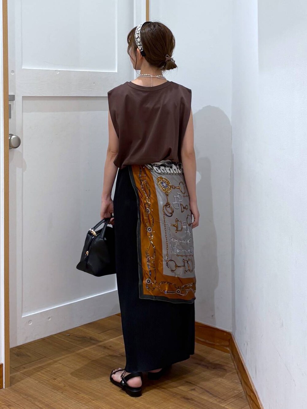 ブラック系のショルダーバッグ、ブラック系のスカート、ブラック系のサンダルを着用したレディースの夏コーディネートの3枚目の写真