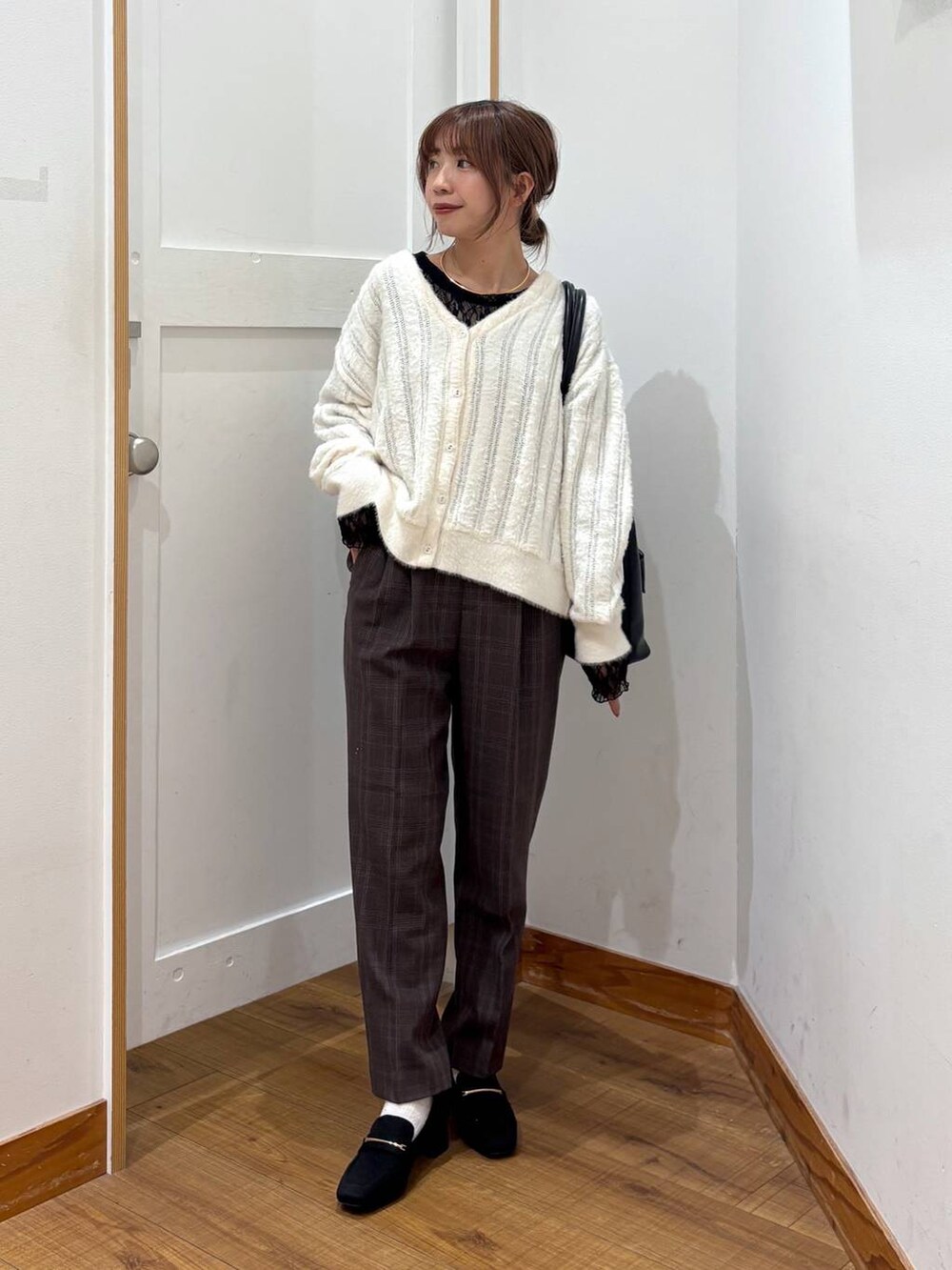 ブラック系のローファー、ブラック系のトートバッグ、ホワイト系のカーディガン/ボレロを着用したレディースの秋コーディネートの5枚目の写真